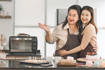 Happy asian family senior mother and daughter cooking in kitchen - obrazy, fototapety, plakaty