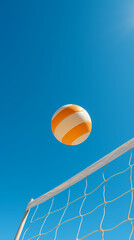 Volleyball flies over beach volleyball under blue sky and sunshine