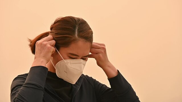 Asian woman wearing an N95 mask for protect bad air pollution. PM2.5 levels meaning the air quality posed a health hazard.