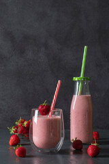 Indian strawberry lassi or smoothie on gray background. Traditional ayurvedic healthy drink with...