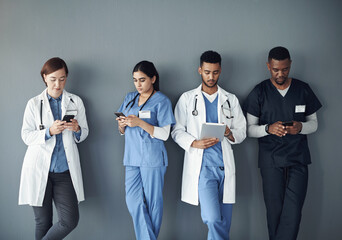 Nurses, doctors and row by wall with technology for waiting with social media, online and...