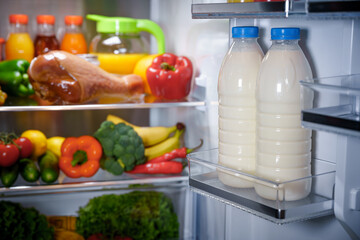 Products in the refrigerator. Bottles of milk in the fridge