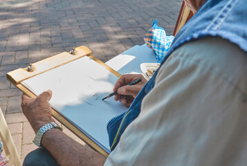 A man is drawing a picture on a piece of paper. Craft and DIY concept.