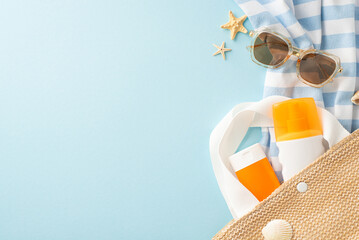 A collection of summer beach essentials including a striped towel, stylish sunglasses, sunscreen,...