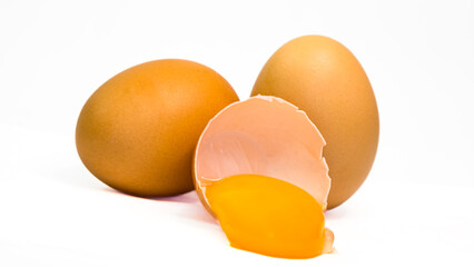 Chicken eggs, both unopened and opened, revealing the inside and yolk, white background, isolated