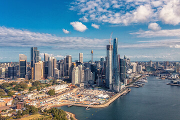 Fototapeta na wymiar Aerial view modern skyscrapers and buildings near ocean and cloudy sky. Sydney, Australia.