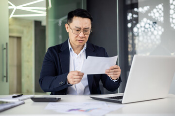Businessman analyzing document at modern office desk