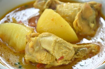 chicken drumsticks massaman curry with slice potato and onion on bowl