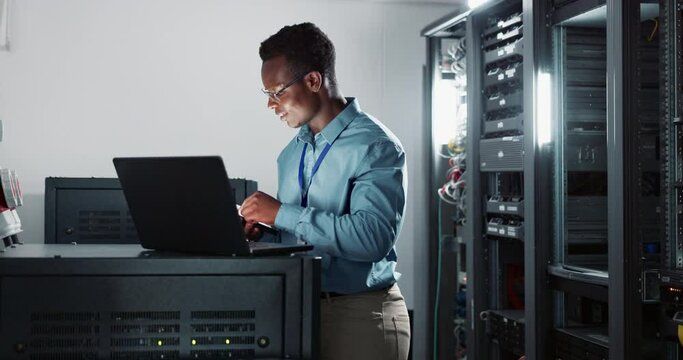 Laptop, coding and man engineer in server room for software, cybersecurity or programming. Professional, computer and African male technician working with online database with technology in office.