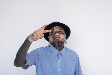 Stylish Asian man with full face tattoos and multiple body piercings on a clean white background,...