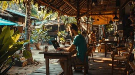 Fototapeta premium A man is sitting at a table in a restaurant with a laptop open