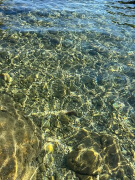 Sea pebbles and stones in the transparent water 