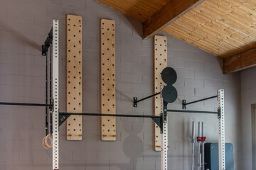 A gym with peg boards on the wall and a black and white rack.