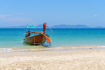 Traditional ong-tail Taxi boat on the beautiful ocean beach in summer day, Andaman sea, Krabi Thailand.