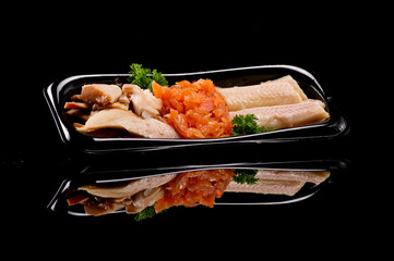 Diverse visgerechten op zwarte reflecterende plaat.