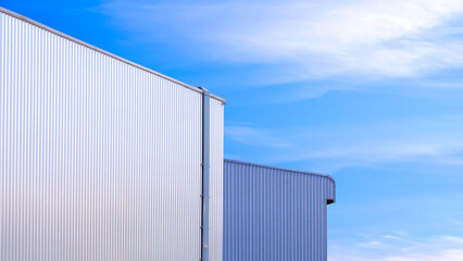 Two white and gray aluminium wall of industrial warehouse buildings against blue sky background in minimal style, low angle and perspective side view