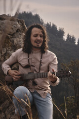 man playing guitar in the mountain