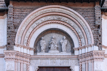 The entrance arch of Bologna San Petronio Basilica features a sculptural triad set within a finely...