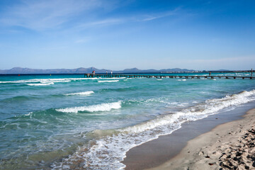 Port de Alcudia, Mallorca, Balearic Islands, Spain. Rough Mediterranean sea on windy day, beautiful turquoise colour of the water. 
