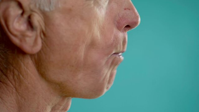Elderly Man eating red apple, close-up. Healthy lifestyle and food. Vitamins for teeth.