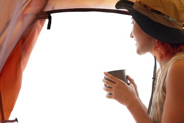 A woman is sitting in a tent with a cup of coffee in her hand. She is smiling and enjoying her drink