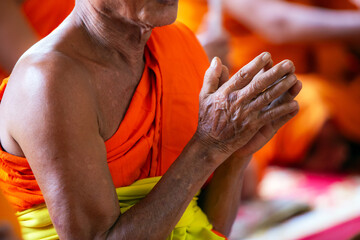Thai monks prayer hands on their chests to pray in religious ceremonies.