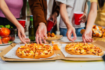 .Young Asian students gather with friends for a pizza party, laughing and sharing slices. Enjoying fast food delivery, they embody diversity and togetherness in a relaxed, enjoyable lifestyle.