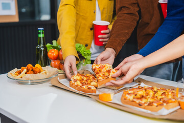 .Young Asian students gather with friends for a pizza party, laughing and sharing slices. Enjoying fast food delivery, they embody diversity and togetherness in a relaxed, enjoyable lifestyle.