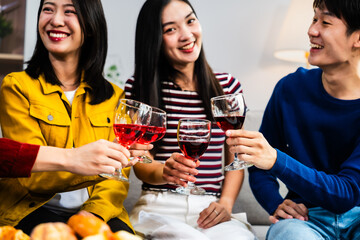 Young Asian friends gather in the living room, cheering and celebrating while watching a soccer match on TV. Their joy and togetherness exemplify the excitement of sports, friendship.