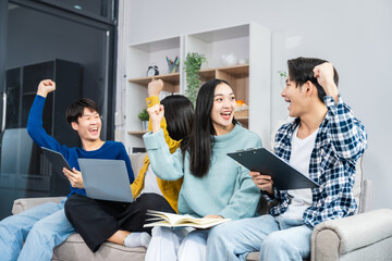 A group of young Asian friends enjoy cheerful conversations and laughter while lounging on the sofa...