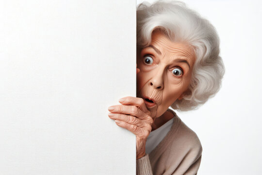 Surprised old woman cautiously peeks around a corner against a white background