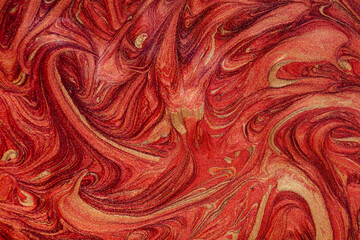 Closeup of red fluid metallic paint textured background