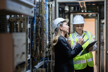 The power plant serves as a cornerstone of the energy industry, with male and female engineers...