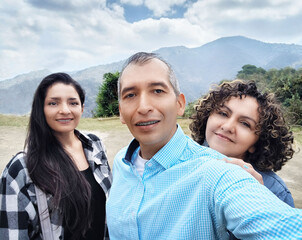 Hombre y dos mujeres Guatemaltecos de viaje en un ambiente natural al aire libre.
