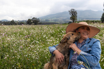 errier dog kissing its owner on the cheek in a field with flowers in the Ecuadorian Andes