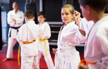 Children sparring in pairs to practice new moves in karate class