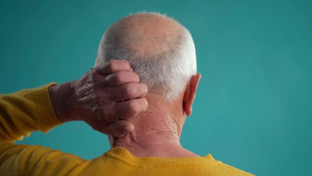 Old man standing over blue background backwards thinking in doubt with hand on head