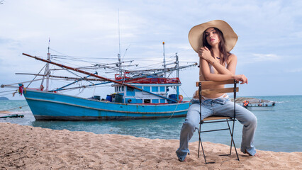 Woman Caucasian stay on beach wearing bikini and jeans with hat and sunglass on the sea beach is...