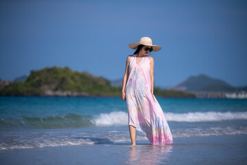 Happy sexy Asian traveller woman wear colorful beach dress and hat show enjoys on tropical beach vacation in summer holidays	 - 796759294