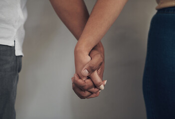 Couple, love and holding hands for support, care and solidarity or romance with studio background....
