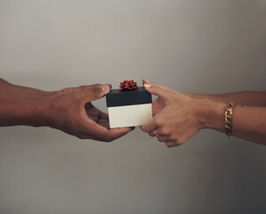 Couple, hands and gift box for love, anniversary and celebration for surprise or romance. Package,...