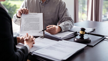 Male lawyer showing contract and pointing the signature box for signing while explaining and consultation about legislation agreement and terms data of business contract to businessman in law firm