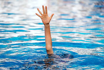 The hand of a drowning child in the pool.