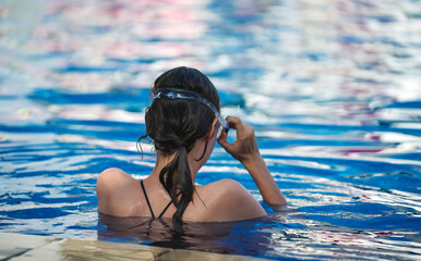 Girl swimmer in swimming goggles in the pool.