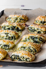 Spinach and feta pastries on a parchment lined baking sheet.
