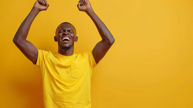 A Man In A Yellow Shirt Is Jumping Up And Down With His Hands In The Air