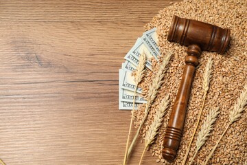 Agricultural business. Dollar banknotes, judge's gavel, wheat ears and grains on wooden table, flat...