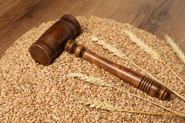 Judge's gavel, wheat ears and grains on wooden table. Agricultural deal