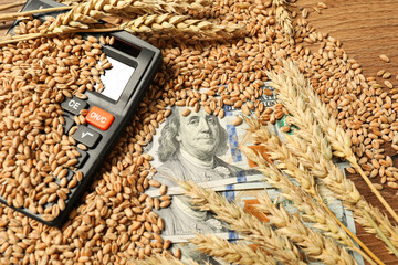 Wheat ears, grains, dollar banknotes and calculator on wooden table, closeup. Agricultural business