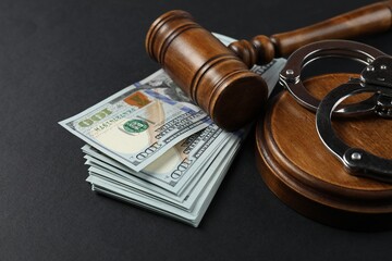 Judge's gavel, money and handcuffs on black background, closeup